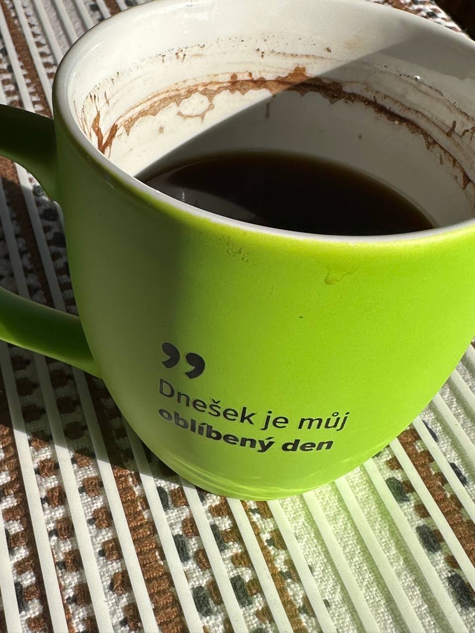Lime-green ceramic mug of coffee printed with the Czech phrase “Dnešek je můj oblíbený den” — today is my favorite day.